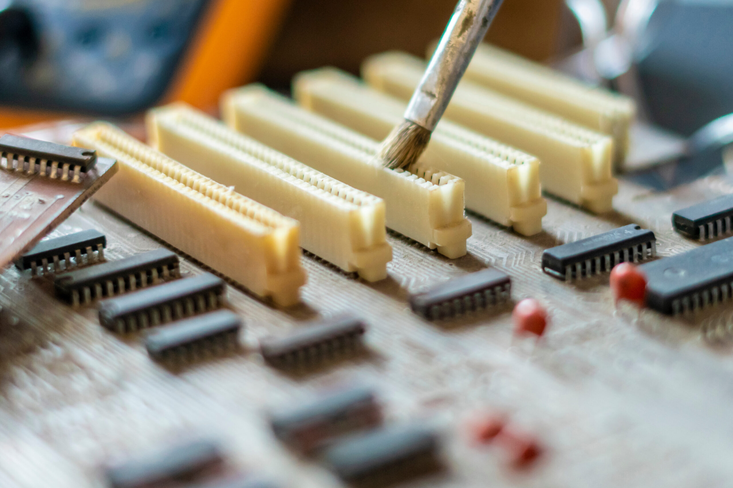 engineer removes dirty dust from the computer board using a brush